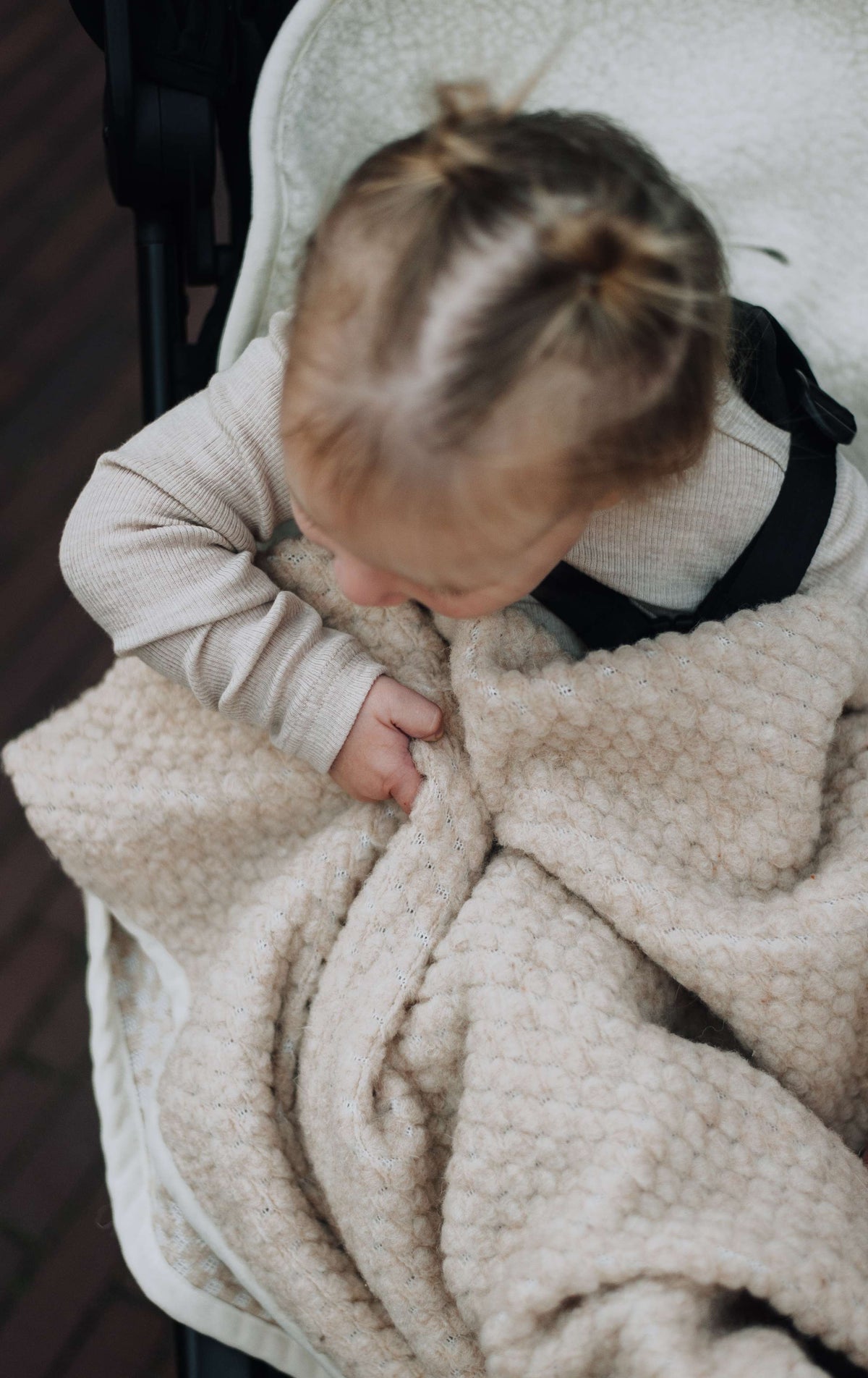 Baby met beige KICO Label bouclédeken van merinowol