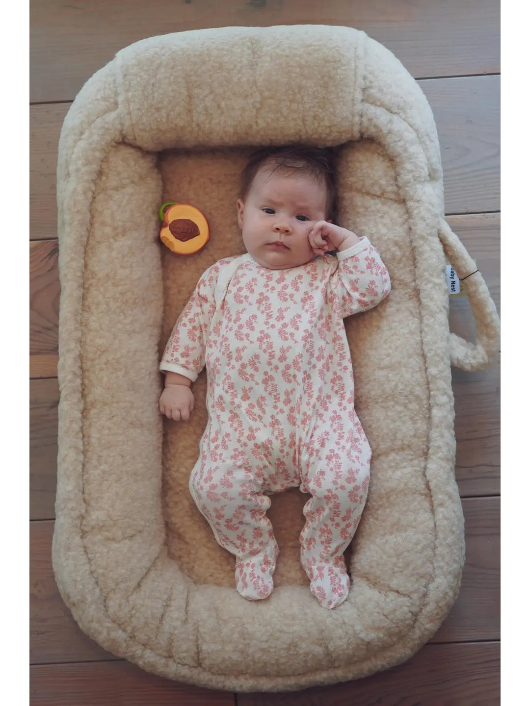 Sfeerfoto met baby in wollen babynest van We Are Wovens – sample, afwerking wijkt af van het uiteindelijke model